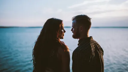Image d'un couple qui se regarde au bord de l'eau